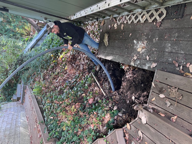 Directional Boring Services performed by Rush Plumbing - man with hose going into ground